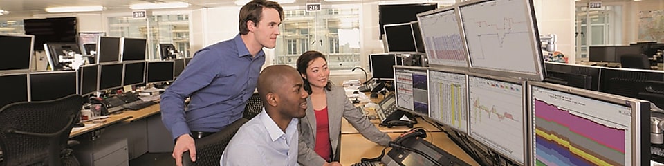 L'équipe de la salle de trading examine les données sur de multiples écrans d'ordinateurs