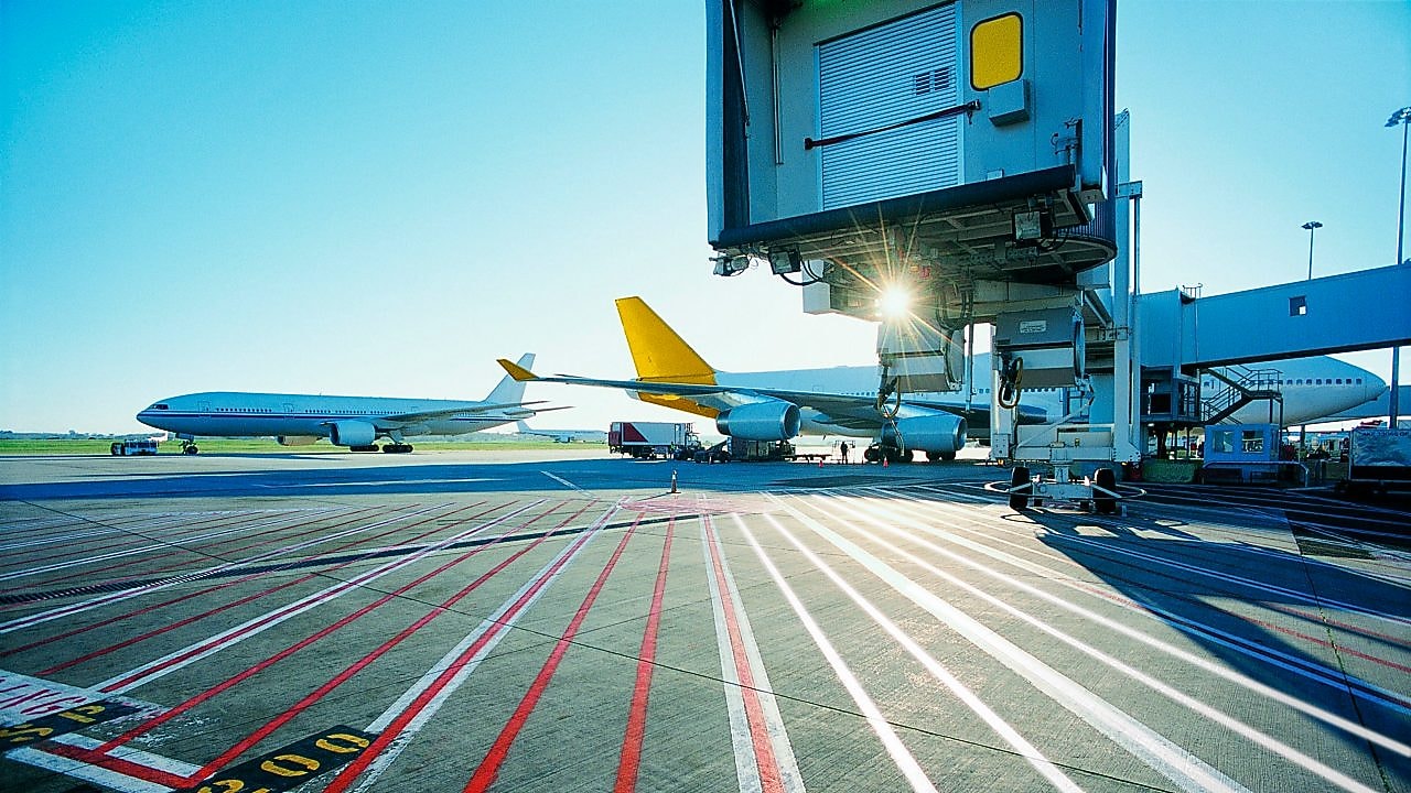 Vue matinale d'une piste d'aéroport et lever de soleil sur deux avions