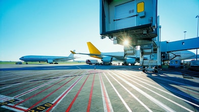 Vue matinale d'une piste d'aéroport et lever de soleil sur deux avions