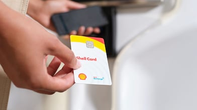 Une personne utilise une carte euroshell dans une machine à carte