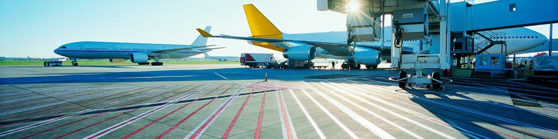 Vue matinale d'une piste d'aéroport et lever de soleil sur deux avions