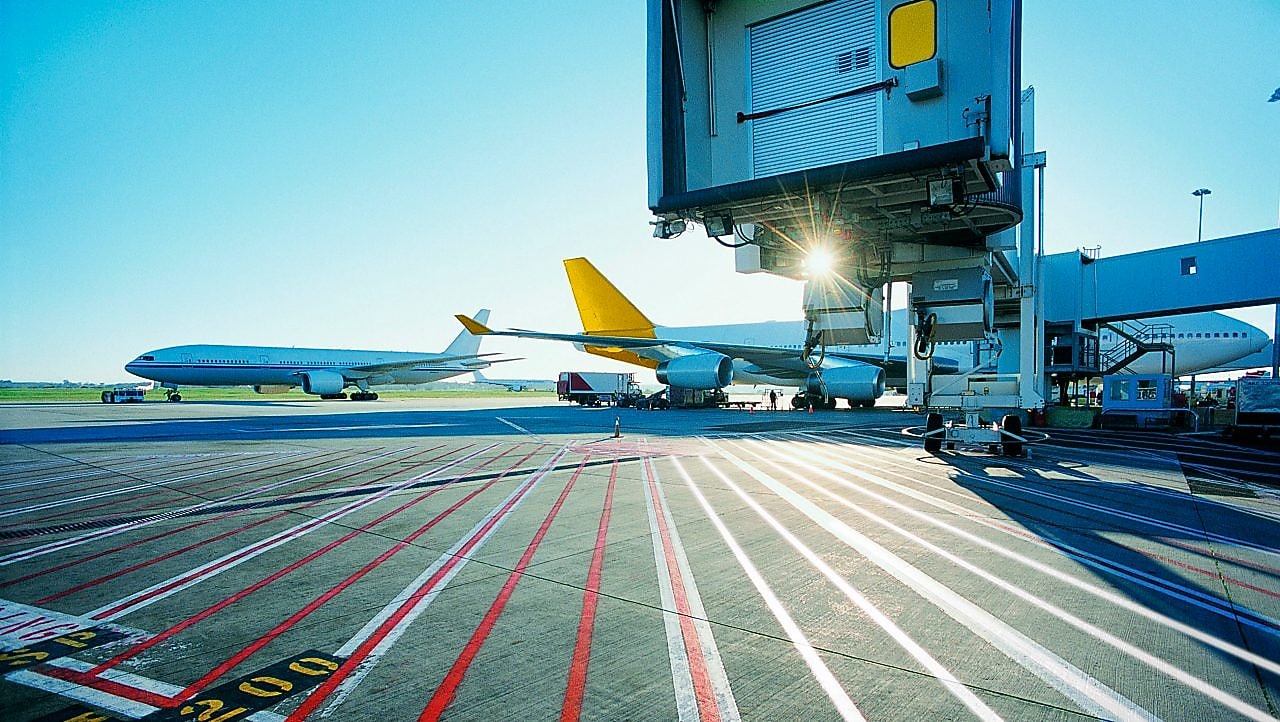 Vue matinale d'une piste d'aéroport et lever de soleil sur deux avions