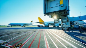 Vue matinale d'une piste d'aéroport et lever de soleil sur deux avions