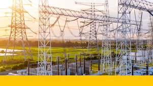 Poste électrique avec lignes de transmission haute tension interconnectées et équipements au coucher du soleil.