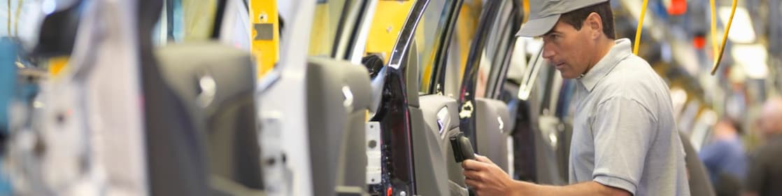 homme qui regarde une machine avec un câble à la main