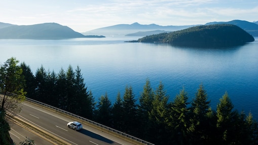Voiture roulant sur l’autoroute le long d’un grand lac