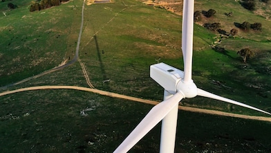 Éolienne, parc éolien dans un champ vert et chemin de terre.