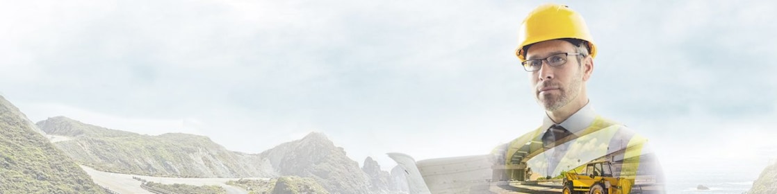 Un travailleur portant un casque jaune transposé sur un fond de route dans des montagnes