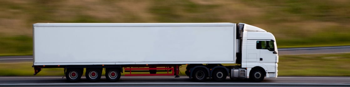 Homme lisant un document, incrusté sur un arrière‑plan représentant un site et un camion jaune.