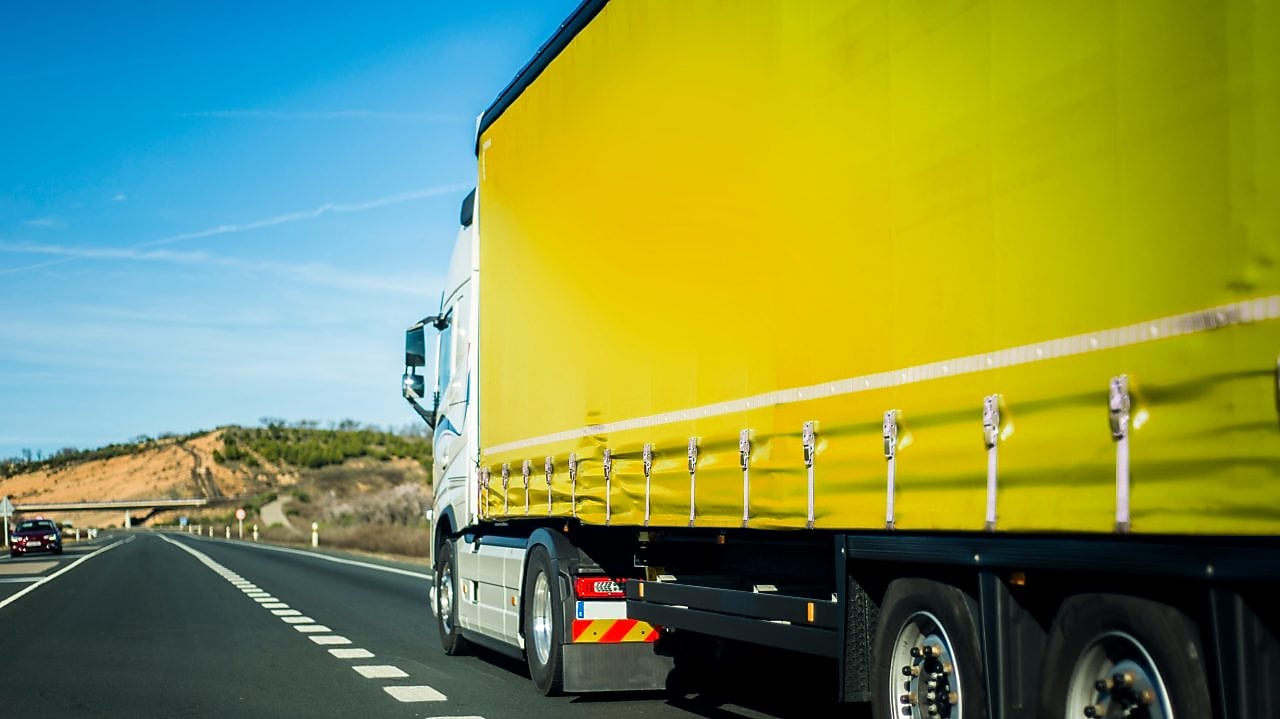 Yellow truck driving on road
