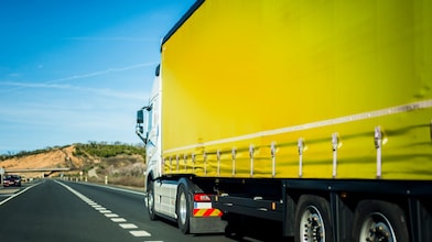 Yellow truck driving on road
