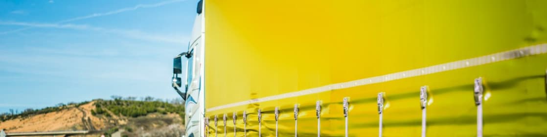 Yellow truck driving on road
