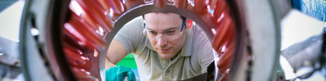 Un homme transvase des granules de plastique pour les mettre dans un malaxeur