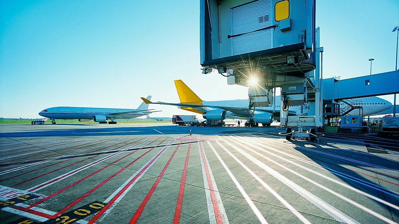 Vue matinale d'une piste d'aéroport et lever de soleil sur deux avions