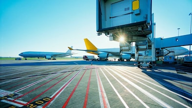 Vue matinale d'une piste d'aéroport et lever de soleil sur deux avions