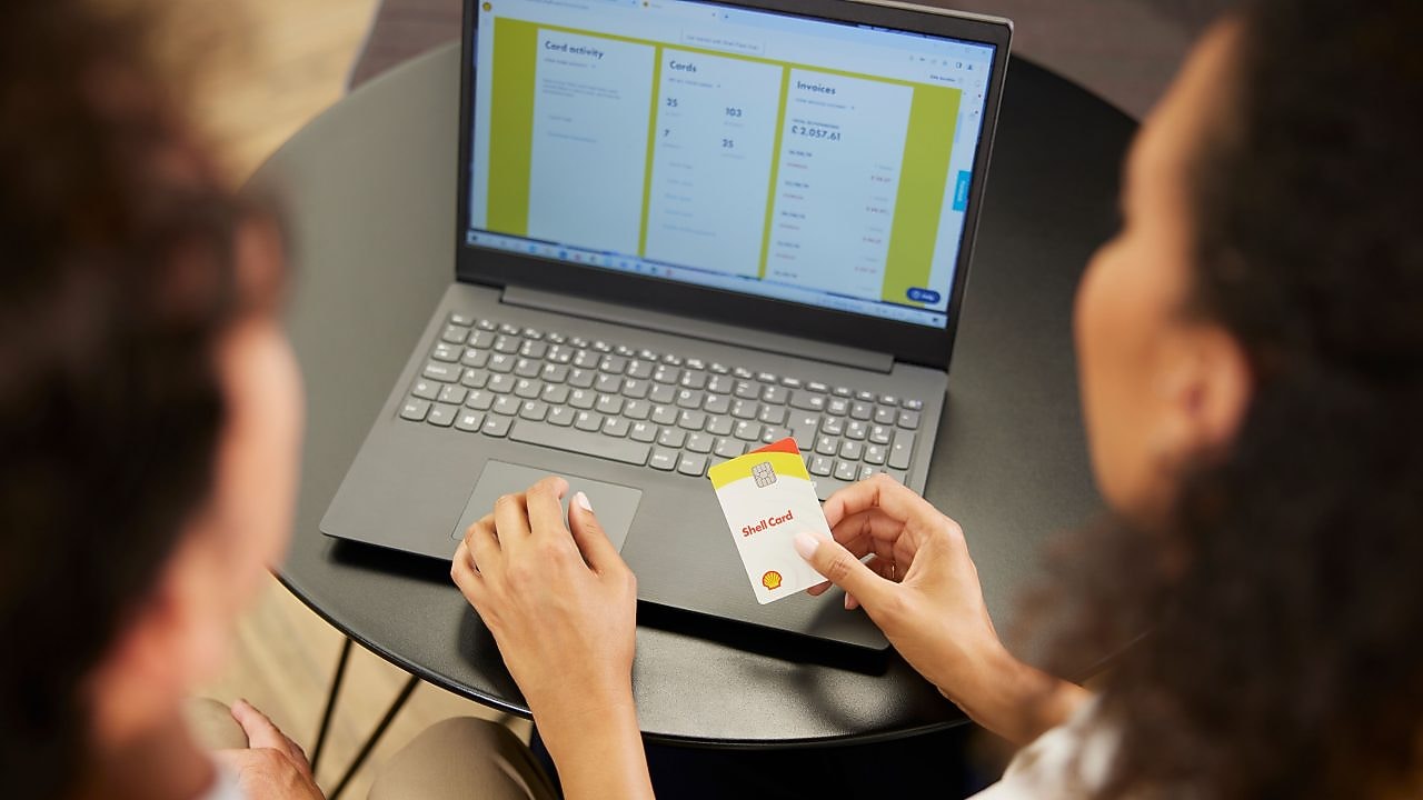 Male and Female Shell customers in an office, looking at a laptop, and discussing a Shell card.