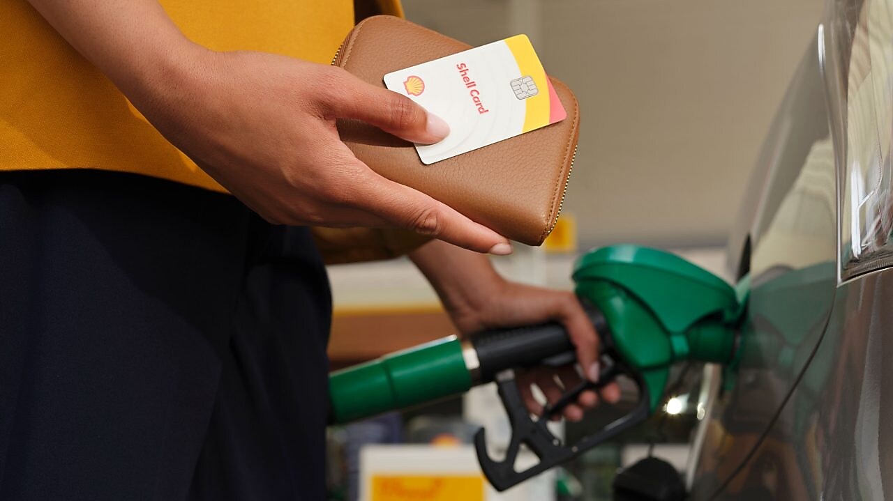 Un homme insère la carte euroshell dans la fente de la machine à cartes