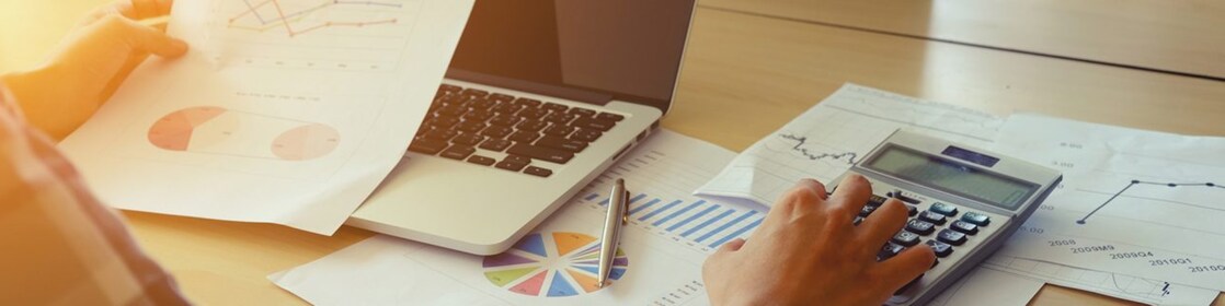 Une personne travaille sur un bureau et vérifie une calculatrice.