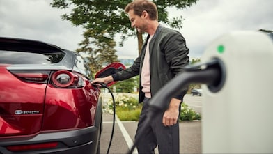 Conducteur rechargeant son véhicule électrique sur une borne Shell Recharge