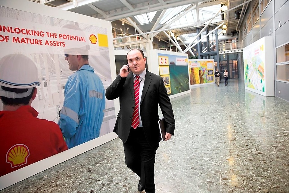 Andy Kneen marchant et téléphonant dans un bureau Shell
