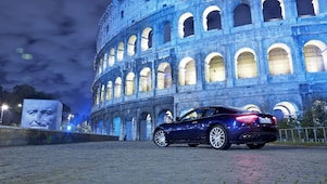Une voiture noire la nuit devant le Colisée