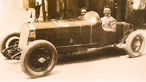 Photo en noir et blanc d'Enzo Ferrari assis dans l'une des premières Ferrari
