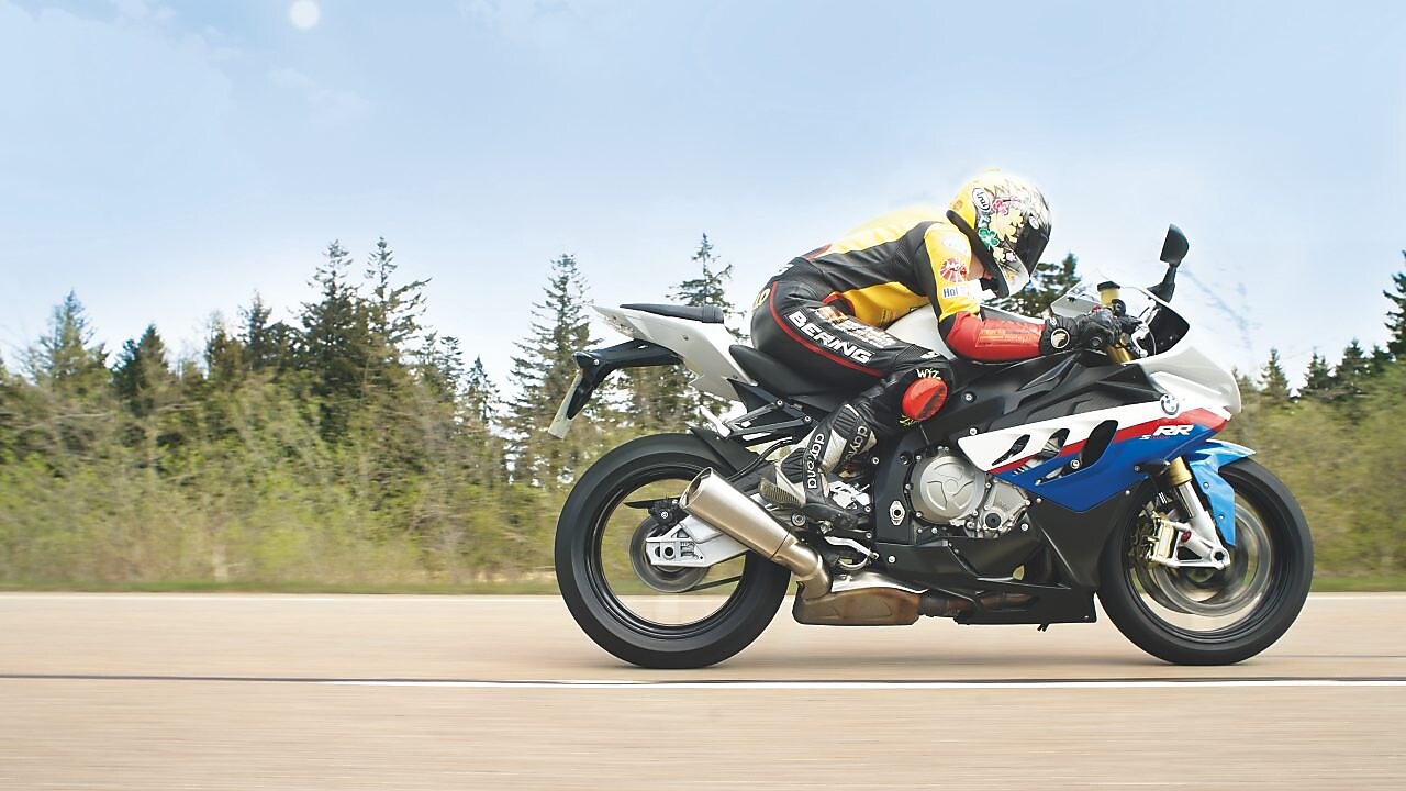 Un homme à moto sur une route de campagne
