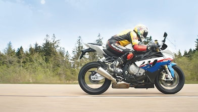 Un homme à moto sur une route de campagne
