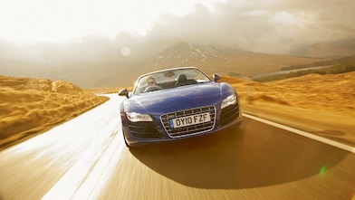 Une voiture roule dans l'eau sur une route de campagne