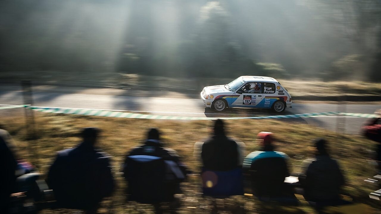 Une voiture de rallye sur la route devant une foule de spectateurs