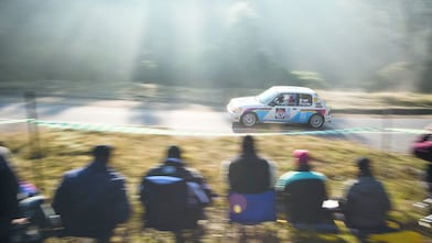 Une voiture de rallye sur la route devant une foule de spectateurs