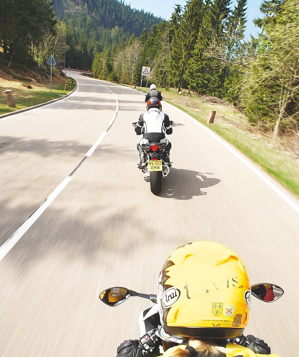 Trois motos qui roulent sur une route de montagne