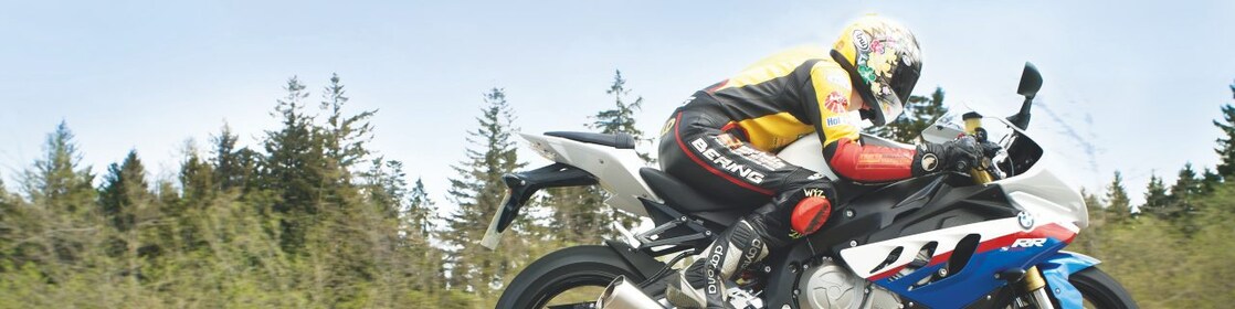 Un homme à moto sur une route de campagne