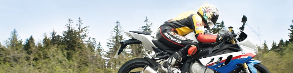 Un homme à moto sur une route de campagne