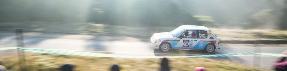 Une voiture de rallye sur la route devant une foule de spectateurs