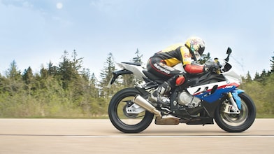 Un homme à moto sur une route de campagne