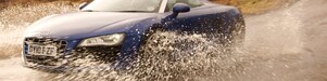 Une voiture roule dans l'eau sur une route de campagne
