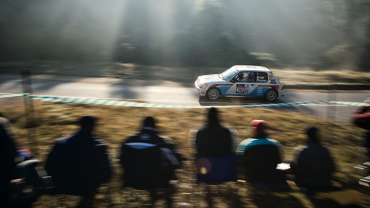 Une voiture de rallye sur la route devant une foule de spectateurs