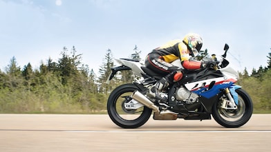 Un homme à moto sur une route de campagne