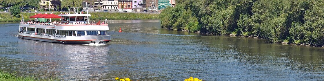Un bateau sur un fleuve avec un magnifique village européen à l'arrière-plan