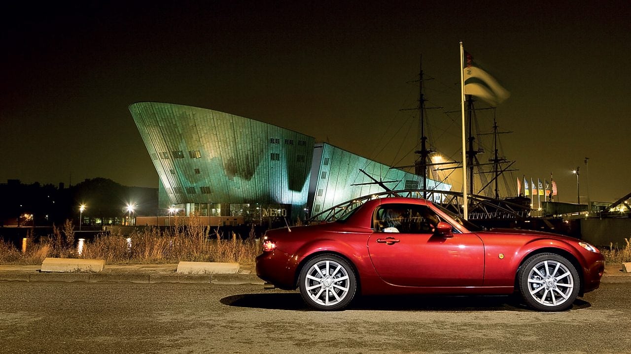Une voiture rouge stationnée dans les rues d'Amsterdam