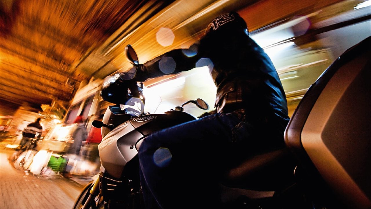 Un homme sur une moto dans Marrakech de nuit