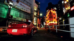 Une Mazda roule de nuit dans Tokyo