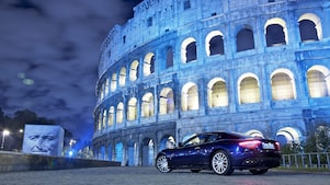 Une voiture garée devant le Colisée de nuit