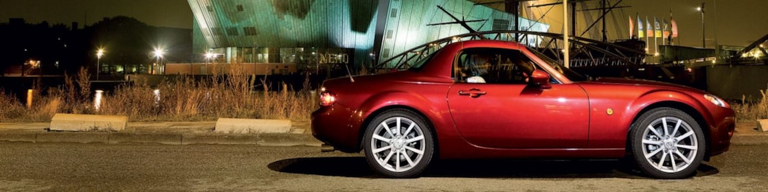 Une voiture rouge stationnée dans les rues d'Amsterdam