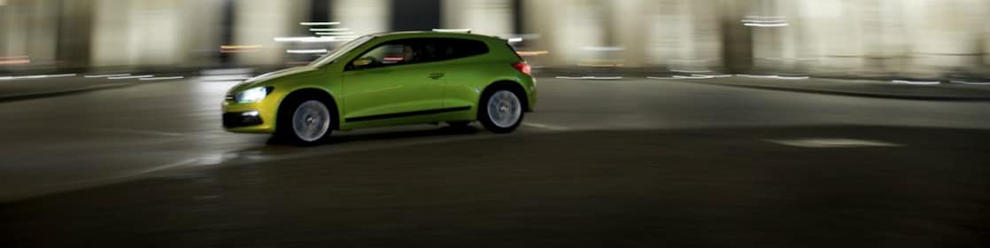 une voiture verte fonce dans la nuit