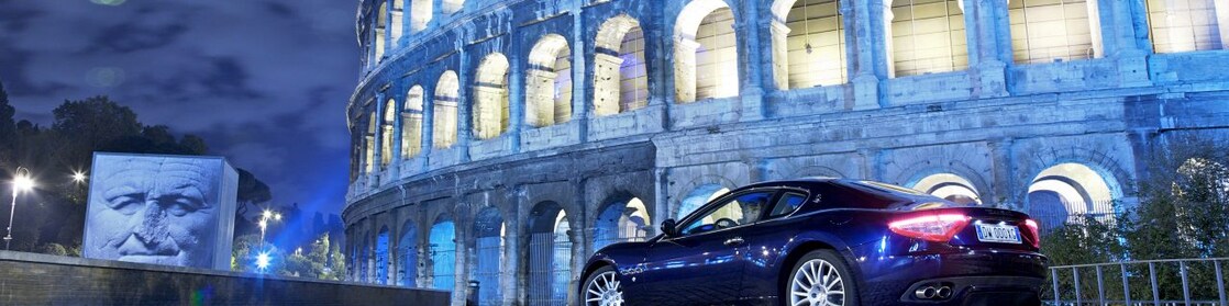 Une voiture garée devant le Colisée de nuit