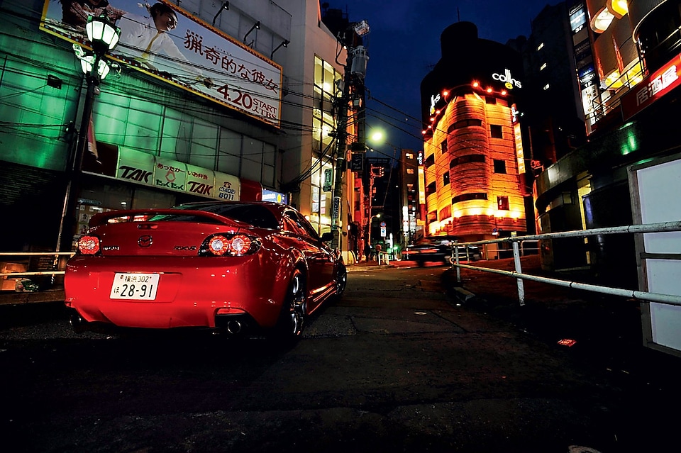Une Mazda roule de nuit dans Tokyo