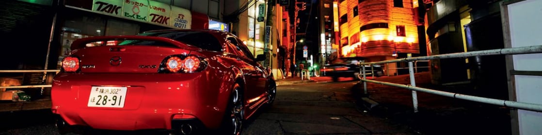 Une Mazda roule de nuit dans Tokyo