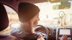 Une jeune femme consulte les instructions du GPS de sa voiture